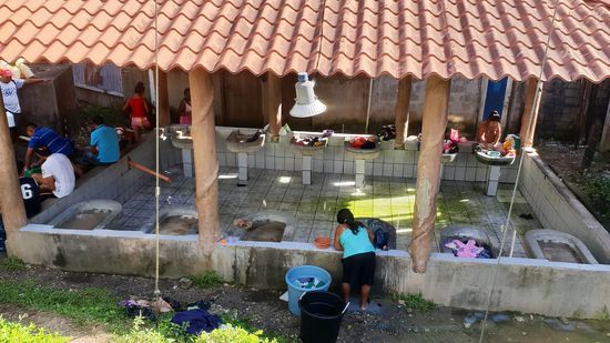 Hier wird noch mit der Hand auf neben dem Dorfplatz gewaschen.