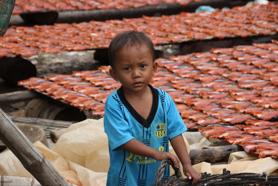 Im Hintergrund werden Fische 1-2 Tage in voller Sonne getrocknet. Halten dann bis zu 6 Monate.