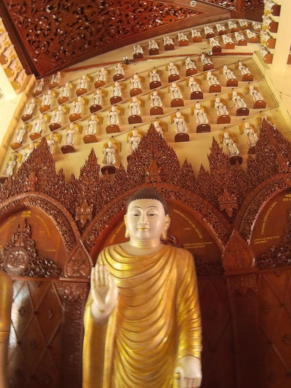 Hinter dem Buddha die kleinen Abbilder an der Wand sind wohl Spenden für einen besonderen Wunsch