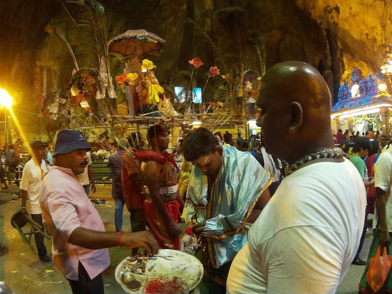 Vorne einige Helfer mit dem Tablett,  im Hintergrund einer der Gläubigen mit einer Opfergabe,  die Streben sind in seiner Haut verankert