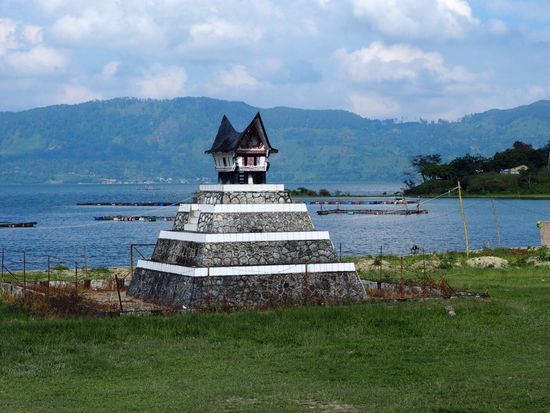 Traditionelles Grab, geschmückt mit typische Häusern im Batak-Stil und einem Kreuz