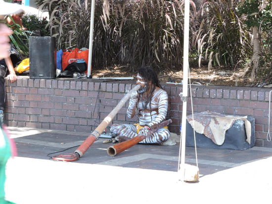 Aboriginie-Straßenmusiker mit einem Didgeridoo