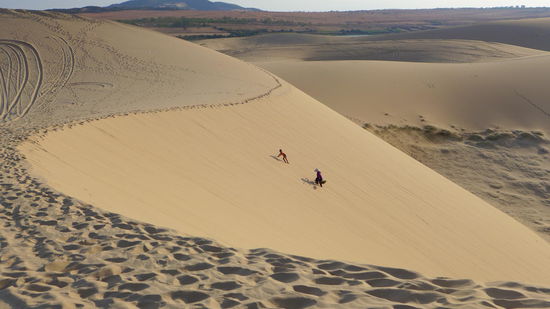 Was für ein Foto! Eine Oma spaziert mit einem kleinen Mädchen und einer Gemüsebarre die Sanddünen hinauf. Das macht natürlich niemand freiwillig, vor allem mehrfach. Außer für die zwei Werbefotografen, die wir aus dem Bild geschnitten haben. Das Motiv haben wir einfach mal geklaut. 