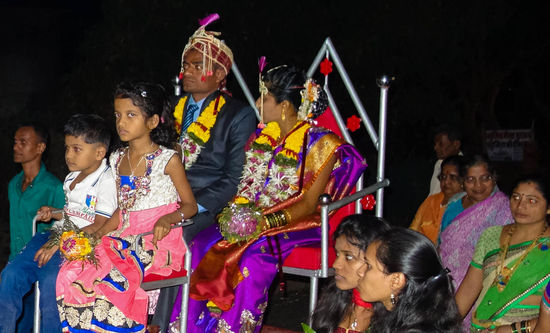 Das Brautpaar fährt auf einem von Pferden gezogenen Wagen durchs Dorf