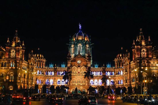 der nachts farbig beleuchtete Bahnhof Chhatrapati Shivaji Terminus