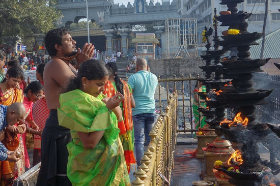 Vorne beten, die dahinter schlagen kleine Kokosnüsse auf die wohl als Opfer dargebracht werden