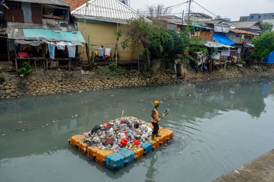Ein Floß beladen mit Müll. Ein Mann fischt Unrat aus dem Wasser. Ich laufe weiter an diesem Gewässer entlang. Dann ändert sich die Gegend, auch das Wasser sieht wieder sauberer aus, so als wären die Flußarme nicht miteinander verbunden.