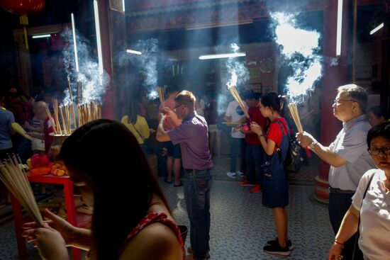 und immer wieder Besucher die mit Räucherstäbchen unterwegs sind
Die Stäbchen werden dann einzeln auf die mit Sand gefüllten Behälter verteilt. Das Tempelpersonal leert diese immer wieder um Platz für die Nächsten zu schaffen.