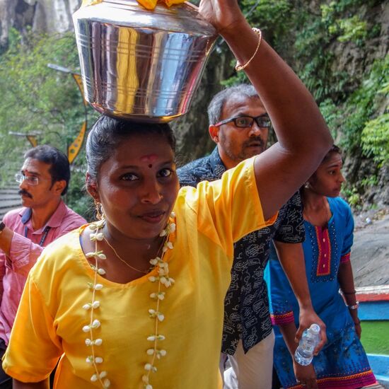 eine der vielen Teilnehmerinnen die einen Topf mit Milch bringen