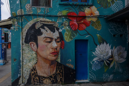 Vor einigen Jahren, als ich gerade in einem Buchladen in einem Bildband über die mexikanische Malerin Frieda Kahlo blätterte, da hatte ich eine seltsame Begegnung. Vielleicht würde ich mich auch so an Frieda Kahlo erinnern, denn ähnlich wie die Gamelan Musik haben ihre Selbst-Porträts etwas magnetisches. Wenn ich mich nicht täusche ist der Künstler hier von Kahlo inspiriert. Kunststudenten wissen sicher wie man solche Gemälde einigermaßen haltbar machen kann. Hier aber blättert die Farbe schon !?