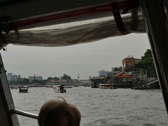 Leben auf und am Fluss: Lastentransportschiffe, Kurs- und Touristenboote, Taxiboote, Restaurants, Lagerhallen, Tempel, Holzhütten, Luxushotels. Die Flussfarbe zeugt von der fehlenden Abwasserreinigung: alles gelangt ungefiltert in den Chao Phraya... und dann ins Meer.