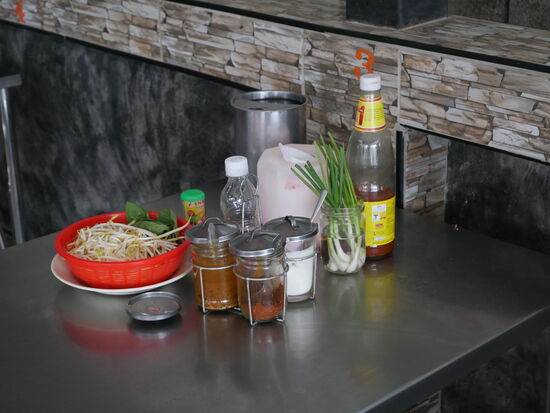 normale „Ausstattung“ in einem Nudelrestaurant: Wasser, Gewürze, Kröuter, Servietten (WC-Papier