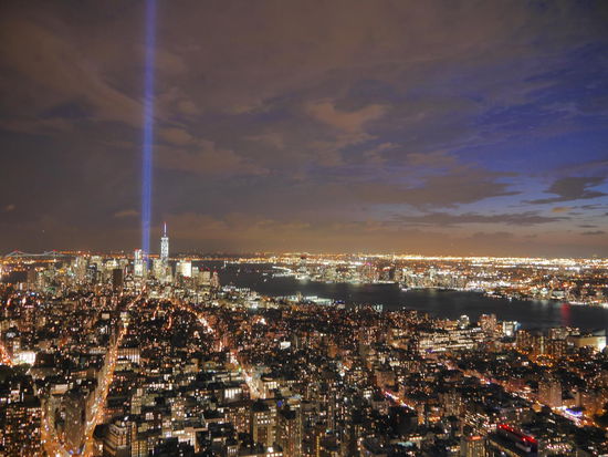 Jedes Jahr in der Woche des 11.09. ragen am ehemaligen Standort der World Trade Center - Ground Zero - zwei Laserstrahlen in den Himmel. Sie dienen dem Gedenken der 9/11 - Opfer. Direkt daneben das neue "One World Trade Center".
