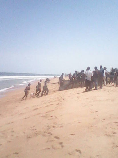 Fischer mit Fangnetz am Strand