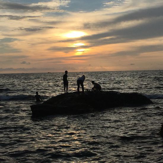 Ein paar Männer fangen Fische in der Dämmerung