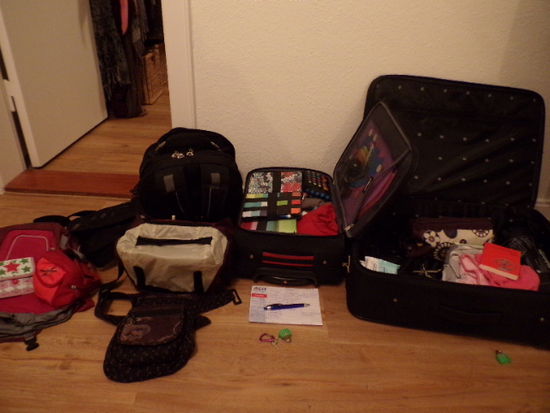 Handgepäck und ein viertel voll fertig gepackter Koffer