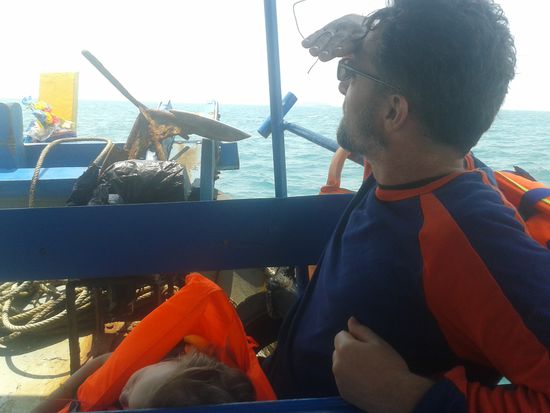 Auf dem Weg zur Insel. Papa späht, Kind schläft.