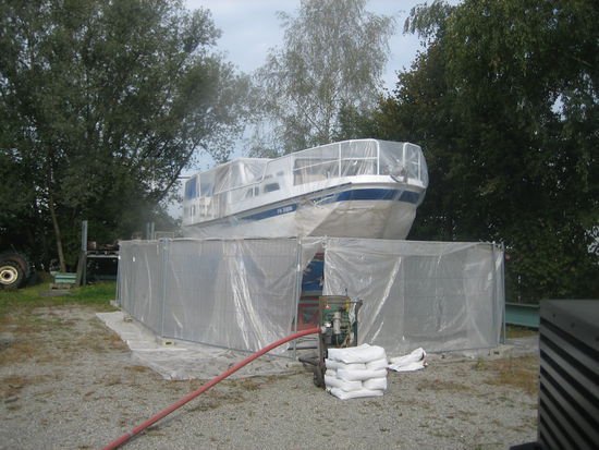 Sandgestrahlt wurde im freien mit auffangwänden aussenrum, Boot komplett verpackt, nur das Unterwasserschiff frei.