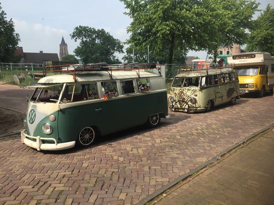 Hippies mit uralten VW-Bussen campen dann auf der Festwiese