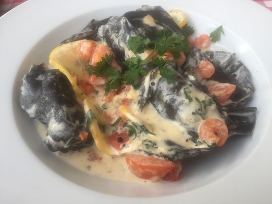 Schwarze mit Lachs gefüllte Teigtaschen in Krabbensauce