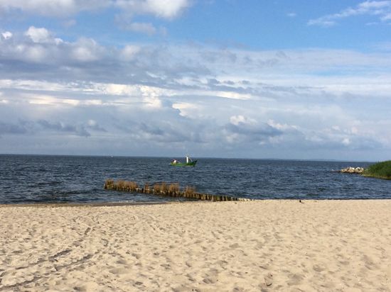 Strand mit heimkehrenden Fischerboot
