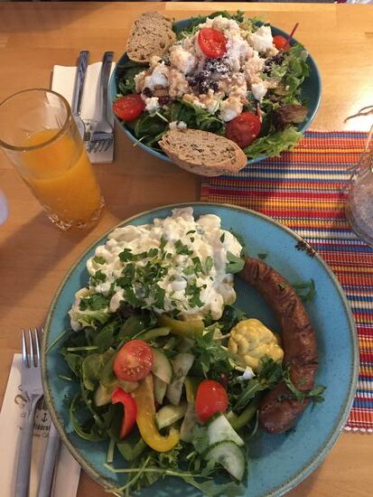 Biorindsbratwurst mit Kartoffelsalat und Salat mit Ziegenkäse