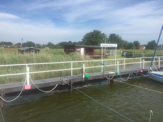 Blick vom Boot auf Hütte des Yachtclubs mit den Sanitäranlagen