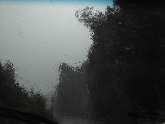 Blick aus der Windschutzscheibe - Scheibenwischer sind so stark wie moeglich eingestellt