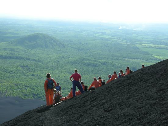 Schon ein gewoehnungsbeduerftiges Bild - orangene Menschen auf dem schwarzen Vulkan!