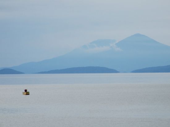 Abendstimmung ueber dem See - im Hintergrund die Vulkane des Festlands