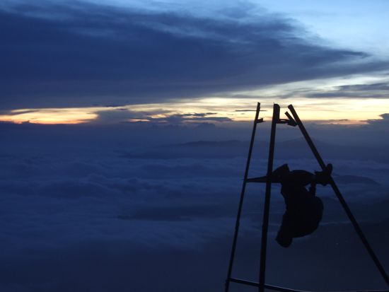 Alex, ein passonierter Kletterer, turnt am Gipfel"kreuz"