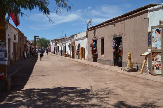 Zentrum von San Pedro de Atacama. Hier reiht sich ein Backpacker Laden an den nächsten. Dazwischen jede Menge Restaurants, deren Besitzer auf der Straße mit ihren Speisekarten werben.