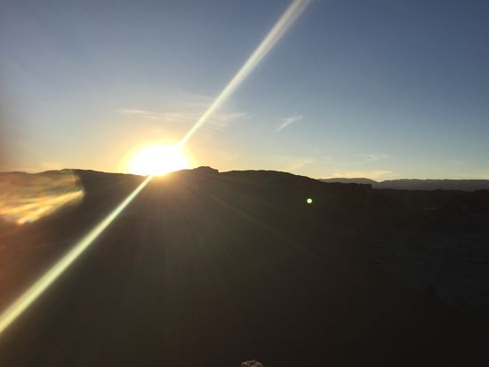 Die Sonne versinkt hinter den Bergen und taucht alles in goldenes Licht.