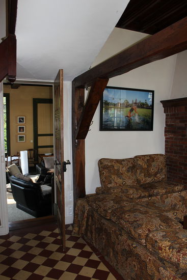 Blick vom Esszimmer ins Wohnzimmer: Holzbalken, alte Fliesen, offene Kamine in fast jedem Zimmer, und ein fast 70 qm2 großes Wohnzimmer mit vielen historischen Relikten.