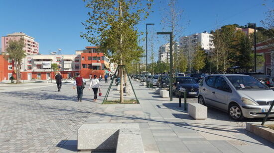 Prachtstraße des Ortes: auf jeder Seite ein acht Meter breiter Fußweg, Bäume, 2m Radweg. Die Straße wird mehrmals täglich mittels Sprengwagen befeuchtet, damit es nicht staubt.