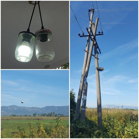 Links unten ist ein Ziegelstein an die Stromleitung gebunden worden, damit diese bei Wind nicht zusammenschlagen.