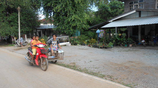 Die Kinder fahren und die Mama sitzt daneben.