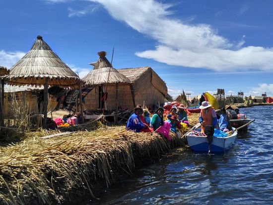 Die Dorfbewohner kaufen ein. Die zwei Damen im Boot haben ihnen Hühnerteile, Brot, Gemüse und Obst (Wassermelone und Bananen) verkauft.
