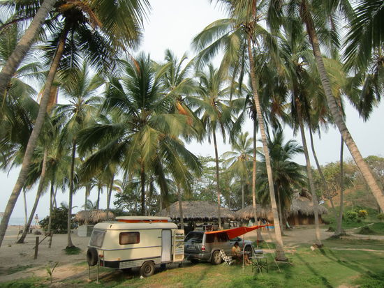 Stellplatz unter Palmen. Ein Paradies war es trotzdem nicht. Im Meer konnte man nicht schwimmen, wegen Strömung und hoher Wellen. Und es gab Sandmücken ohne Ende. Wir sind total zerbissen. Und man musste sich strategisch gut stellen, damit einem nicht die Kokosnüsse auf de Kopf fielen (oder in die Windschutzscheibe) 