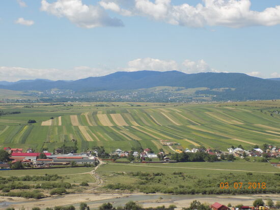 Blick von der Festung in westliche Richtung. Die Berge im Hintergrund gehören zum Naturpark Vânători. Bemerkenswert: Die häufig in Rumänien zu beobachtende kleinteilige Parzellierung der Äcker.