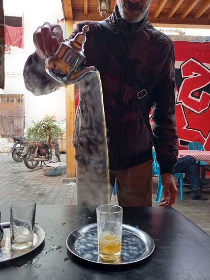 Der Tee wird mehrmals in das Glas und zurück in die Kanne gegossen.