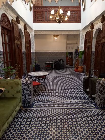 Die Eingangshalle. Mosaik und aufwendige Holzarbeiten prägen die hohen Räumlichkeiten in denen riesige Messingleuchten von der Decke hängen.