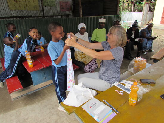 Die Mädchen bekommen ein Kleid und ein Zopfgummi. Außerdem bekommt jedes Kind ein Heft und einen Bleistift.