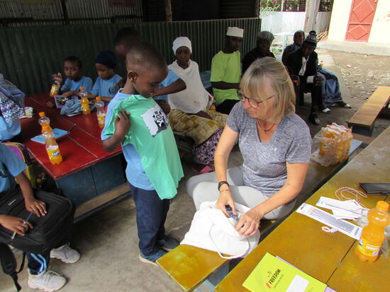 Die Jungen freuen sich über ein T-Shirt und ein Spielzeugauto.