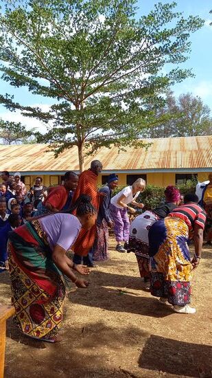 Die Dorfbewohner tanzen und singen und wir machen mit.