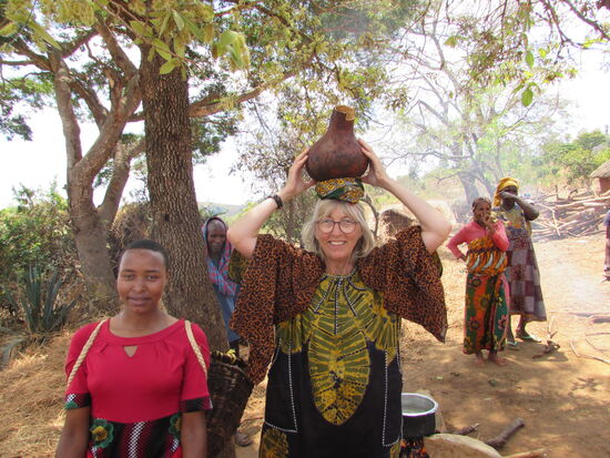 Oben angekommen versuche ich es auch einmal. Ohne das Gefäß festzuhalten geht es nicht. Aber die Iraqw Mädchen lernen es auch schon im frühen Kindesalter.
