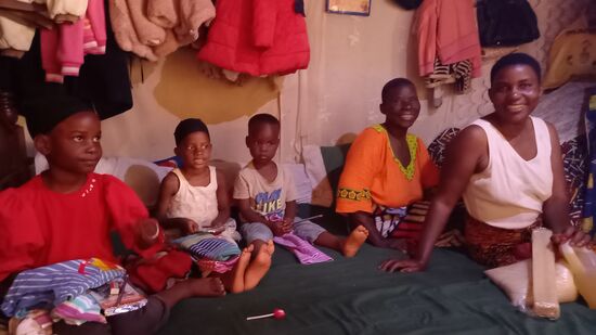 Die ganze Familie sitzt auf dem Bett und strahlt uns an, denn wir haben gerade unsere Geschenke übergeben und mitgeteilt, das die beiden Mädchen einen Schulpaten haben. Dadurch ist der Besuch einer Privatschule, die Schuluniform, Bücher und die Busfahrt finanziert. Das ist für die Familie ein unfassbares Glück!