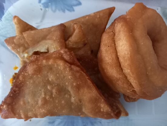 Ein typisches Frühstück- Samosa (gefüllte Teigtaschen), Donats, Weißrot, Avocado und Melone. Dazu Kaffee oder Tee. Was will man mehr  