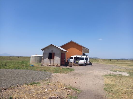 Blick auf die Schule mit dem Küchenhaus und dem Wassertank.