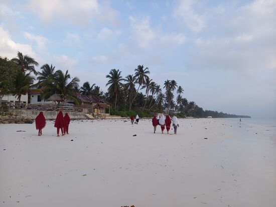 In den Morgenstunden sind viele Schülerinnen am Strand unterwegs.